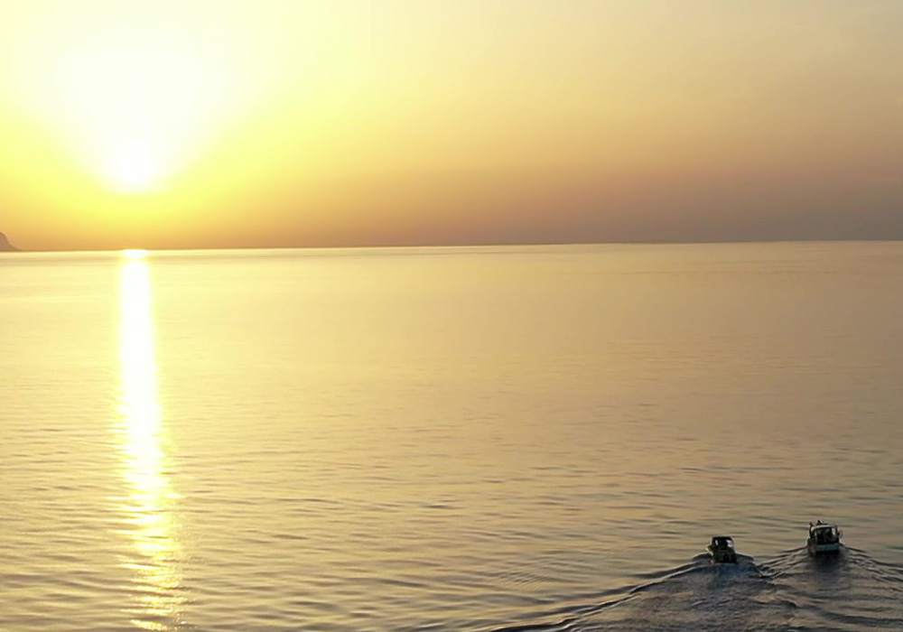 Boats cruising at sunset near Rethymno, Crete